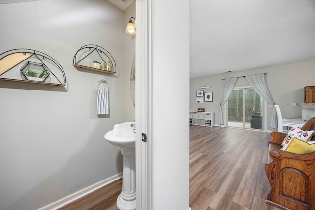 bathroom with wood finished floors and baseboards