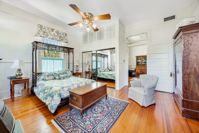 bedroom featuring a towering ceiling, hardwood / wood-style floors, and ceiling fan