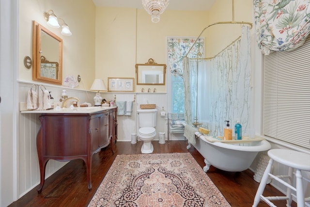 bathroom with wood-type flooring, a tub, vanity, and toilet