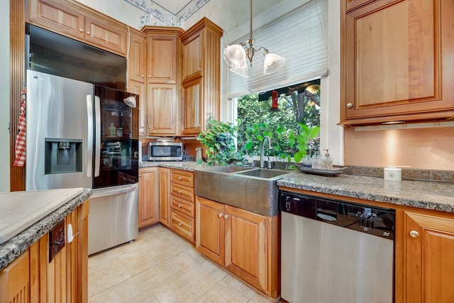 kitchen with stainless steel appliances, sink, pendant lighting, and a notable chandelier