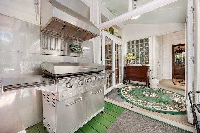 kitchen featuring white cabinetry, vaulted ceiling, hardwood / wood-style floors, and exhaust hood