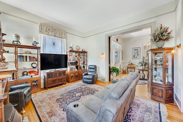 living room featuring an inviting chandelier and wood-type flooring