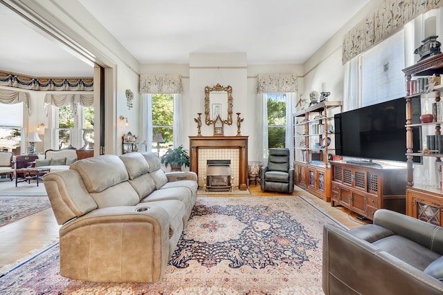 living room with a wealth of natural light, a fireplace, and light hardwood / wood-style flooring