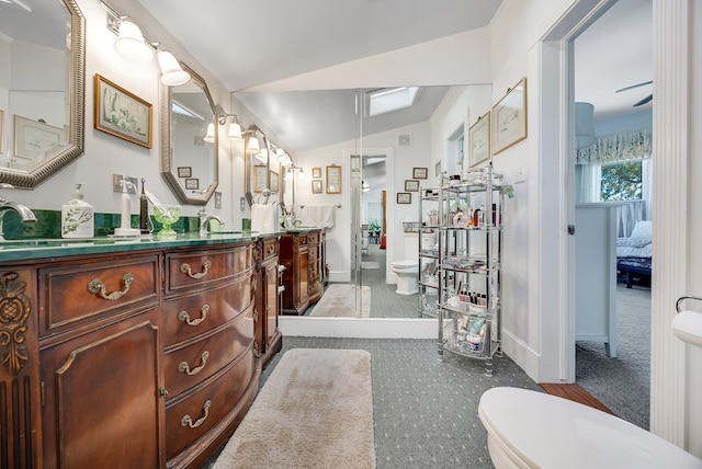 bathroom with vanity, toilet, and vaulted ceiling