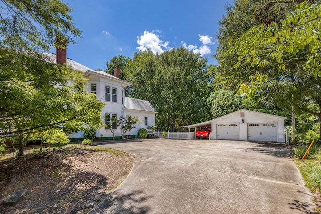 view of front facade featuring a garage, an outdoor structure, and a carport