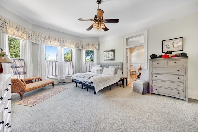 carpeted bedroom featuring multiple windows and ceiling fan