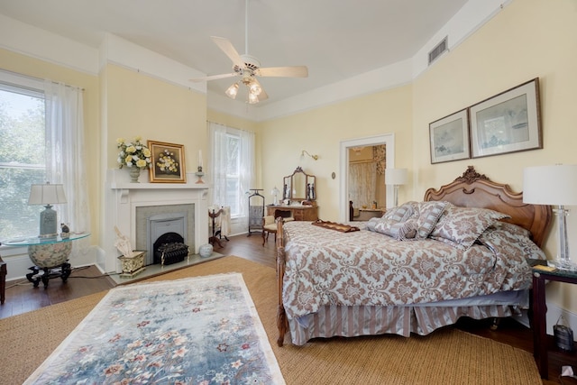 bedroom featuring ceiling fan, hardwood / wood-style floors, and multiple windows