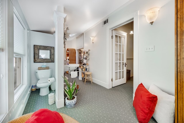 bathroom with crown molding and toilet