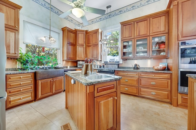 kitchen with sink, hanging light fixtures, a center island, and stainless steel double oven