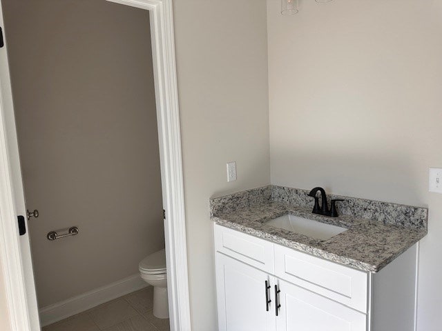 bathroom with tile patterned floors, baseboards, toilet, and vanity