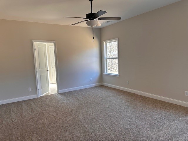 empty room with baseboards, light colored carpet, and ceiling fan