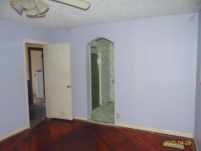 1469 Wall St, Richland, GA 31825 - spare room featuring arched walkways, wood finished floors, baseboards, ceiling fan, and a textured ceiling