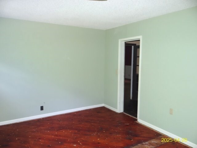 1469 Wall St, Richland, GA 31825 - empty room featuring dark wood finished floors and baseboards