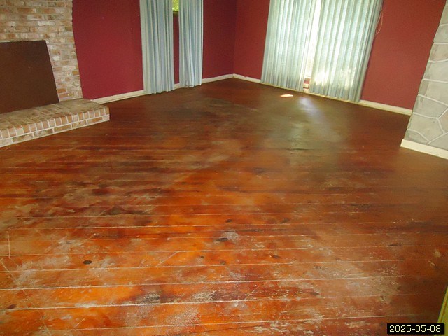 1469 Wall St, Richland, GA 31825 - unfurnished living room with wood-type flooring and baseboards