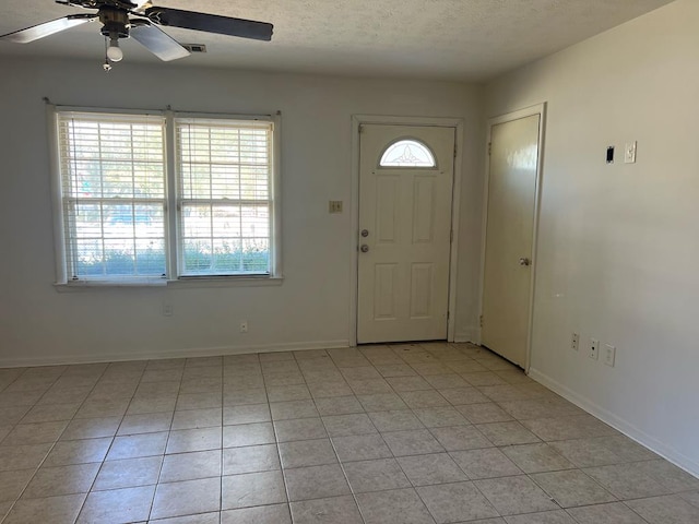 foyer featuring light tile patterned floors, a textured ceiling, and ceiling fan