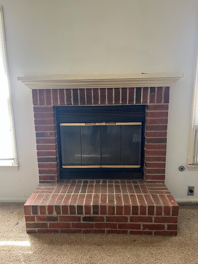 interior details with a brick fireplace and carpet floors