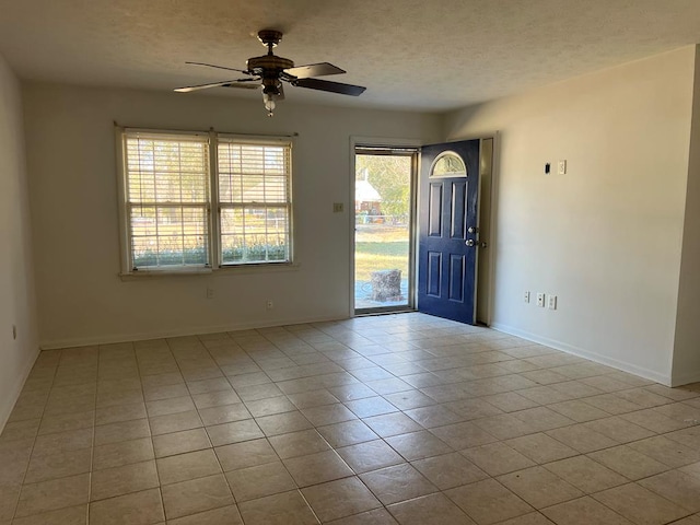 tiled foyer entrance with a wealth of natural light, a textured ceiling, and ceiling fan