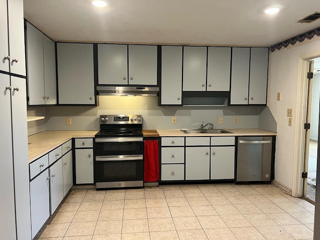 kitchen featuring sink, light tile patterned floors, gray cabinets, and appliances with stainless steel finishes