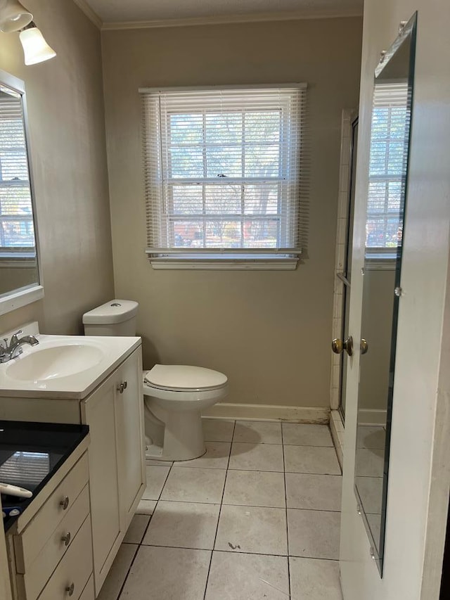 bathroom featuring vanity, plenty of natural light, tile patterned floors, and toilet