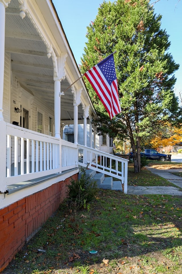 view of side of property featuring covered porch