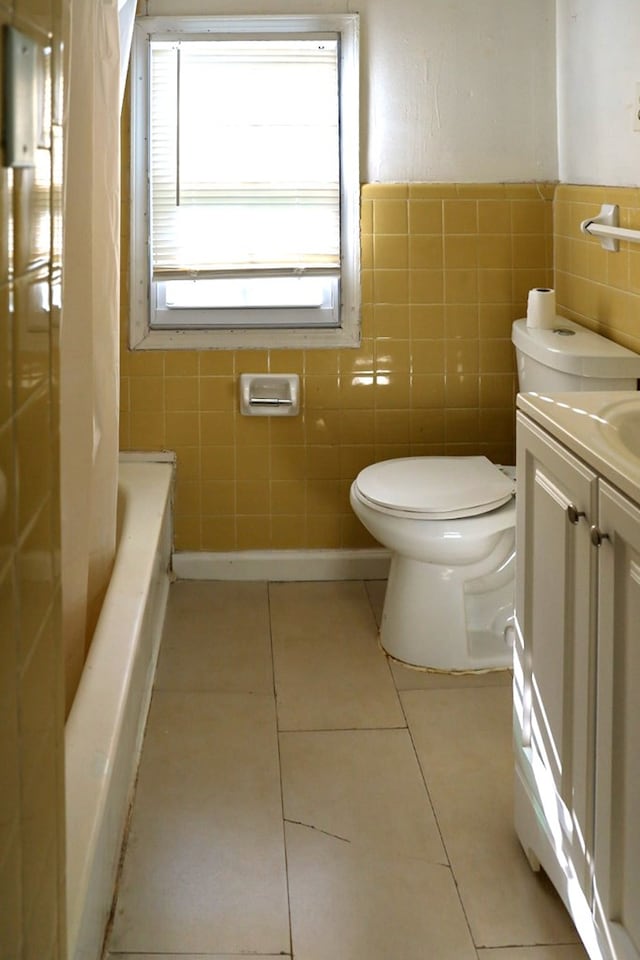 bathroom with tile patterned flooring, vanity, tile walls, and toilet