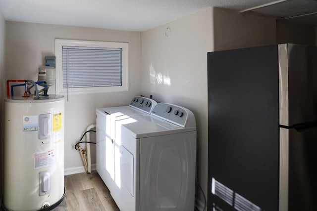 laundry area with washer and dryer, a textured ceiling, light hardwood / wood-style floors, and water heater