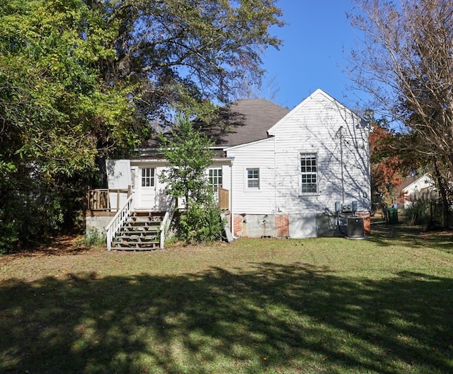 back of house featuring a lawn and a wooden deck