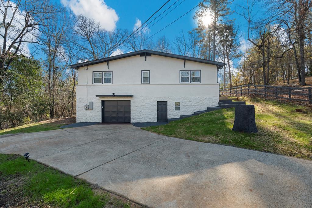 view of property exterior with a garage and a lawn