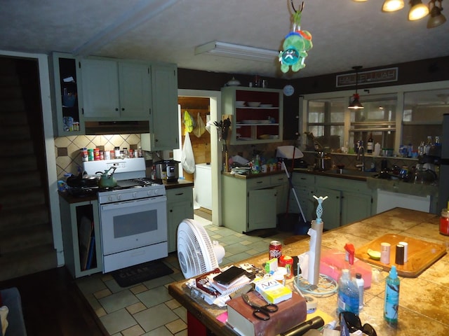 kitchen with sink, decorative backsplash, and white gas stove