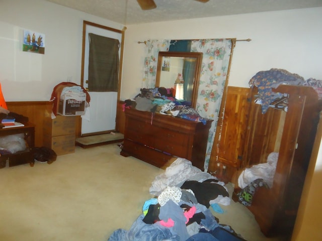 carpeted bedroom featuring wood walls