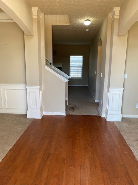 interior space with carpet floors, a textured ceiling, and ornamental molding