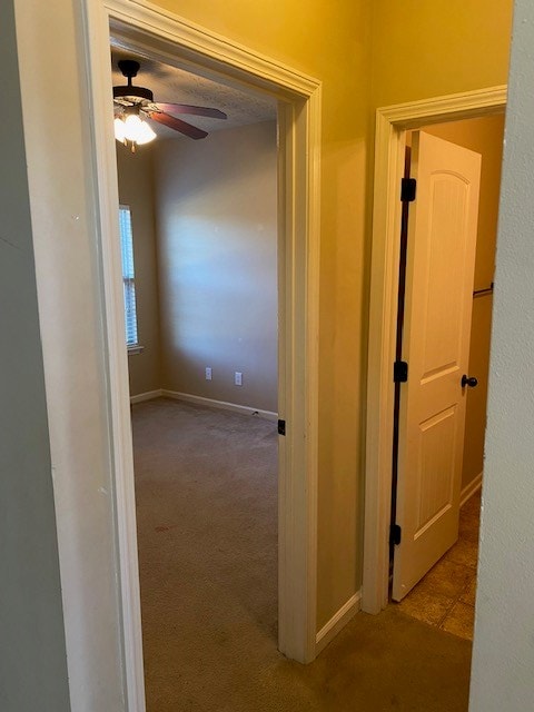 hallway featuring light colored carpet