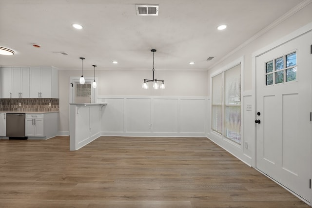 919 54th St, Columbus, GA 31904 - unfurnished dining area with ornamental molding, a chandelier, recessed lighting, light wood finished floors, and a wainscoted wall
