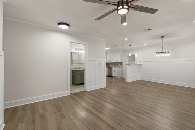 919 54th St, Columbus, GA 31904 - unfurnished living room with crown molding, a ceiling fan, wood finished floors, wainscoting, and a decorative wall