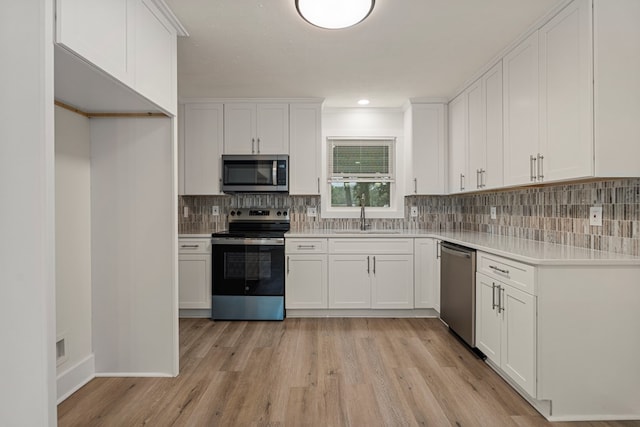 919 54th St, Columbus, GA 31904 - kitchen with appliances with stainless steel finishes, light wood-type flooring, white cabinets, and light countertops