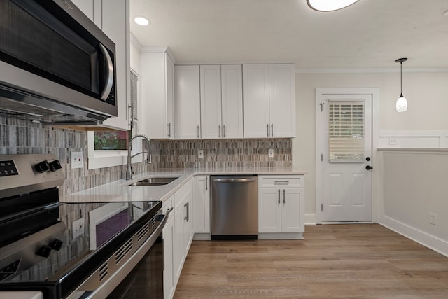 919 54th St, Columbus, GA 31904 - kitchen with appliances with stainless steel finishes, crown molding, light countertops, tasteful backsplash, and white cabinets