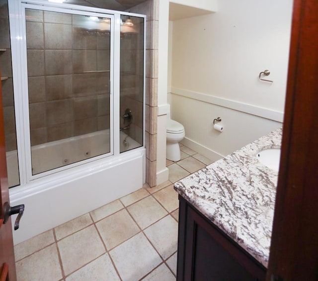 full bathroom featuring tile patterned floors, vanity, toilet, and combined bath / shower with glass door