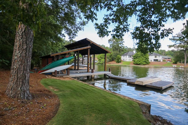 view of dock with a lawn and a water view