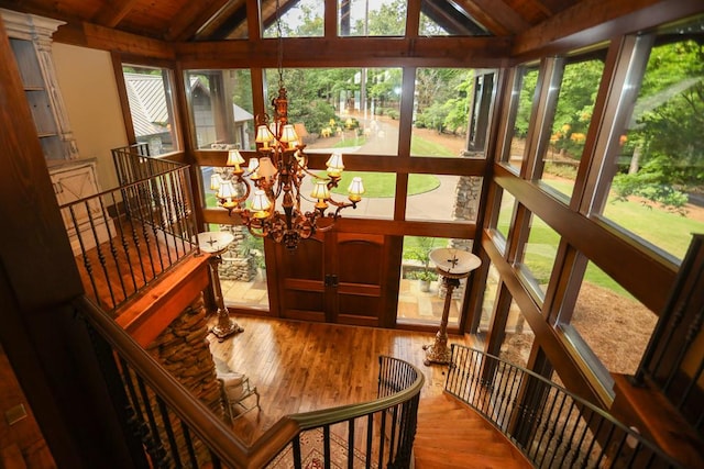 sunroom featuring a chandelier, vaulted ceiling with beams, a wealth of natural light, and wooden ceiling