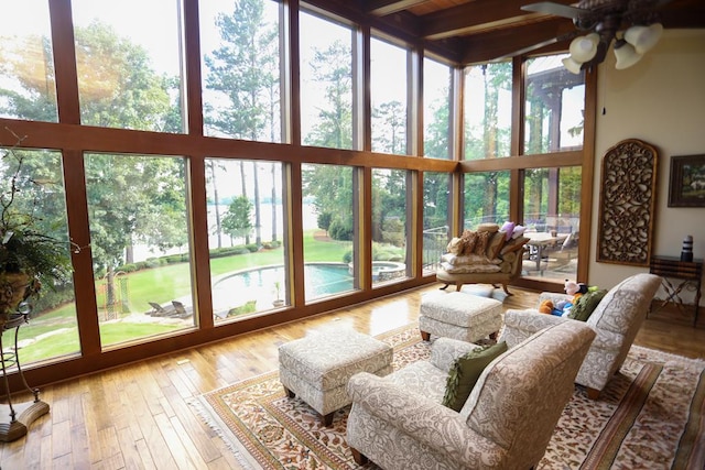 sunroom / solarium featuring beam ceiling and ceiling fan