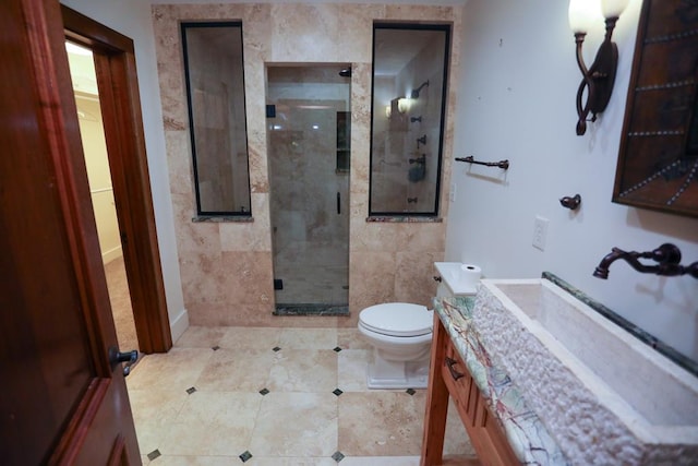 bathroom featuring tile patterned flooring, a shower with door, vanity, and toilet