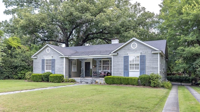 1811 Park Dr, Columbus, GA 31906 - ranch-style house featuring covered porch, a front lawn, a chimney, and view of wooded area