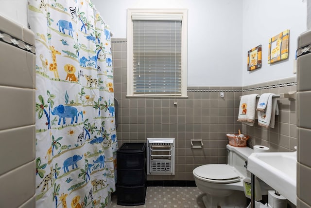 1811 Park Dr, Columbus, GA 31906 - bathroom featuring heating unit, tile walls, tile patterned flooring, a shower with curtain, and a wainscoted wall