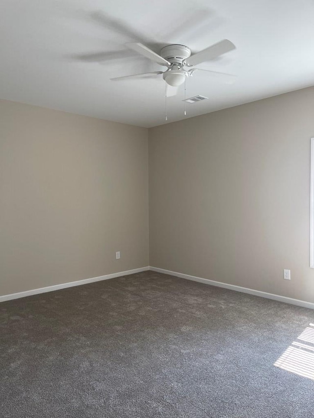 unfurnished room featuring dark carpet and ceiling fan