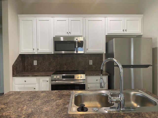 kitchen with backsplash, sink, white cabinets, and stainless steel appliances