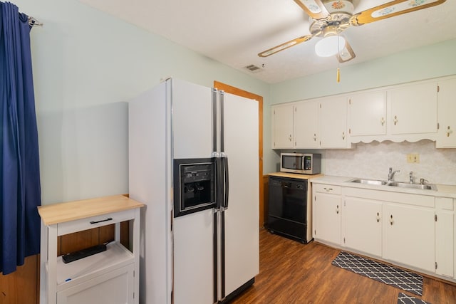 4833 Marino St, Columbus, GA 31907 - kitchen featuring white fridge with ice dispenser, black dishwasher, stainless steel microwave, dark wood finished floors, and white cabinetry