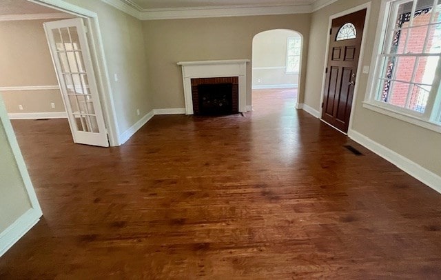 1555 Wells Dr, Columbus, GA 31906 - unfurnished living room with arched walkways, ornamental molding, dark wood-style flooring, healthy amount of natural light, and a fireplace