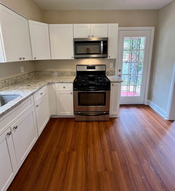1555 Wells Dr, Columbus, GA 31906 - kitchen featuring stainless steel appliances, white cabinetry, dark wood-type flooring, and light stone countertops
