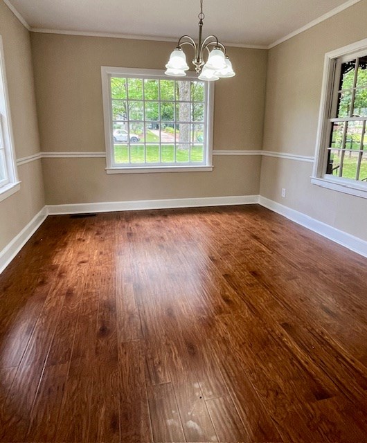 1555 Wells Dr, Columbus, GA 31906 - empty room with dark wood-type flooring, a chandelier, and crown molding