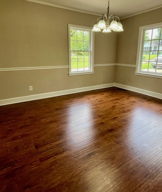 1555 Wells Dr, Columbus, GA 31906 - empty room featuring crown molding, healthy amount of natural light, a chandelier, and dark wood finished floors